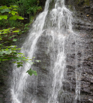 Mittelgroßer Wasserfall über eine Steinwand.