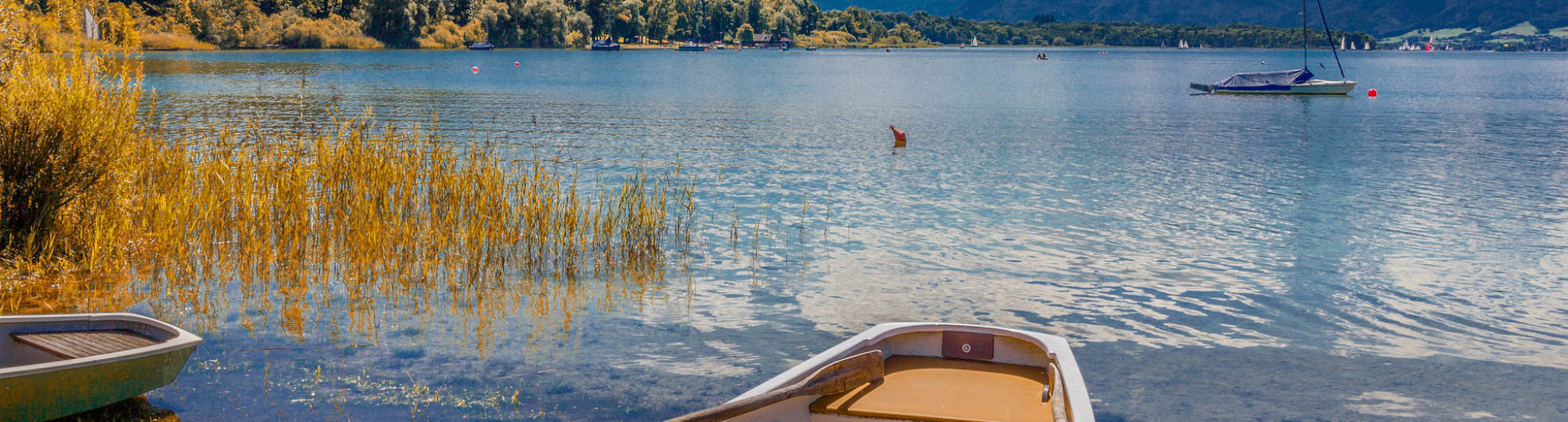 Blick auf den Chiemsee, im Vordergrund zwei Ruderboote.